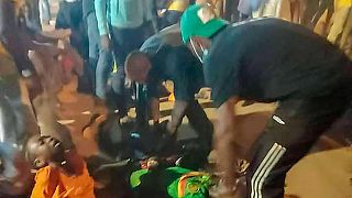 صورة بالهاتف تظهر أشخاصا يحاولون مساعدة ضحايا التدافع خارج ملعب في ياوندي، 24 يناير 2022