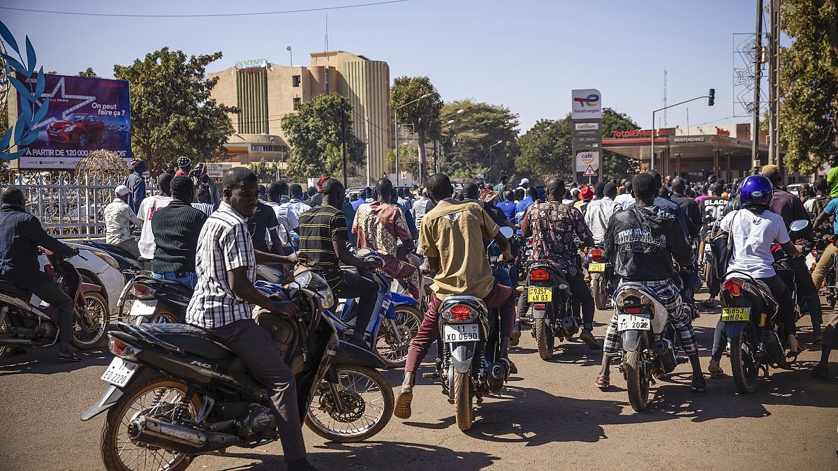 People cheer in support of putschist soldiers near the national television station in Ouagadougou, Monday, Jan. 24, 2022. 