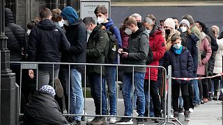 People with mandatory face masks line up to enter the Cathedral in Cologne, Germany, Friday, Jan. 7, 2022.