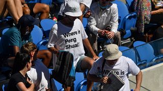 Two spectators wearing "Where is Peng Shuai?" T-shirts are pictured in the stands on day nine of the Australian Open tennis tournament in Melbourne on January 25, 2022.