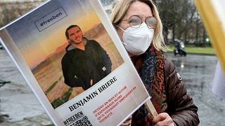 A woman holds a photo of Benjamin Briere during a rally in Paris earlier this month.