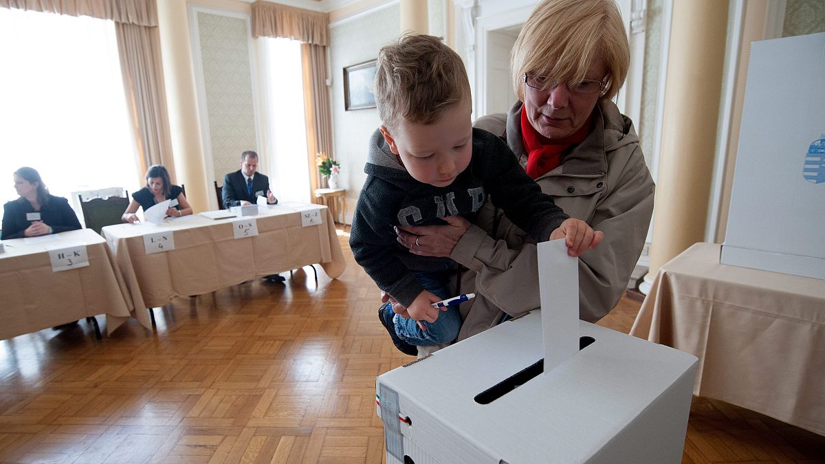 Kisifú segít leadni nagymamája szavazatát a londoni magyar nagykövetségen 2014-ben