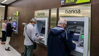 People use an ATM cash point machines at a branch of the Bankia bank in Madrid, Spain, Friday, Sept. 18, 2020.