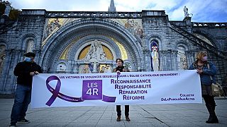 'Katolik Kilisesi'nde cinsel şiddet mağdurları: tanınma, sorumluluk, tazmin, reform talep ediyor' yazan bir pankart tutan protestocular