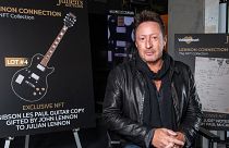 Artist/musician Julian Lennon poses in front of the NFT (non-fungible token) part of "Lennon Connection: The NFT Collection" auction.