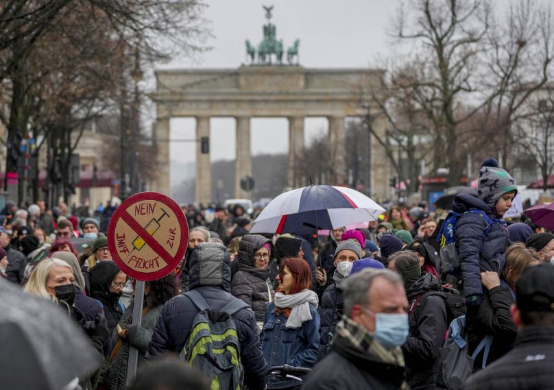People attend a protest rally in front of the Brandenburg Gate against the coronavirus restrictions in Germany, in Berlin, 26 January 2022