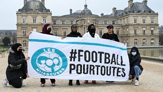 Women calling themselves the "Hidjabers" pose with a banner reading "#football for all" before playing football in the Luxembourg garden facing the French Senate.