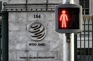 A red traffic light is seen next to the entrance of the World Trade Organization (WTO) headquarters