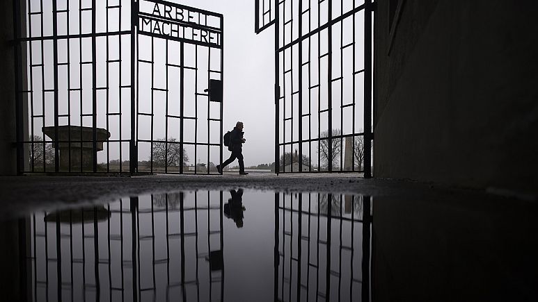 A person walks behind the gate of the Sachsenhausen Nazi death camp with the phrase 'Arbeit macht frei' in Oranienburg, Berlin - Copyright AP Photo/Markus Schreiber