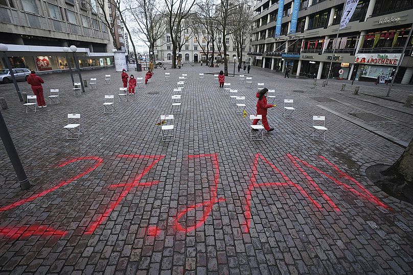 33 white chairs stand on Gerhart-Hauptmann-Platz in the city center during a performance to commemorate the victims of National Socialism in Hamburg - Marcus Brandt/dpa via AP