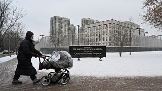 A woman pushes a pram past the US Embassy in Kyiv on January 24, 2022.