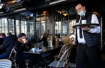 A waiter serves coffee in a restaurant, in Paris on 24 January 2022.