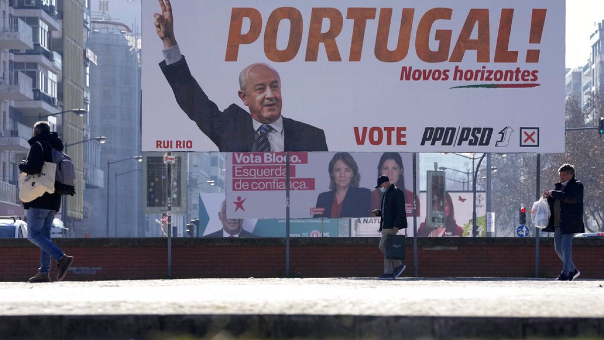 Portugueses caminan ante carteles electorales en Lisboa, Portugal