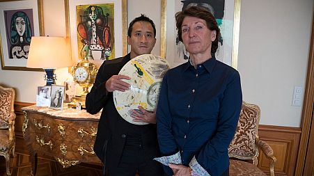 Marina Picasso, right, granddaughter of artist Pablo Picasso, and her son Florian Picasso pose with a ceramic art-work of Pablo Picasso that is NOT going on sale as NFTs