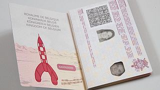 جواز سفر بلجيكي وعلى إحدى صفحاته صورة للصاروخ الذي حمل إلى القمر "تان تان" الشخصية الكرتونية الخيالية التي رسمها الكاريكاتيري البلجيكي هيرجيه