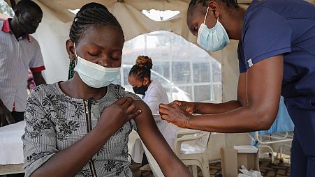 A nurse administers an AstraZeneca vaccination against COVID at a district health centre in Nairobi, Kenya.