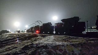 Russian military vehicles prepares to drive off a railway platforms after arrival in Belarus