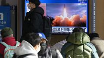 Des personnes regardant une télévision diffusant une image d'archive du lancement d'un missile de la Corée du Nord, à Séoul, en Corée du Sud, dimanche 30 janvier 2022.
