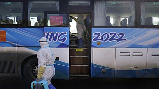 Workers in protective gear disinfect an Olympic shuttle bus ahead of the 2022 Winter Olympics on 30 January 2022, in Zhangjiakou