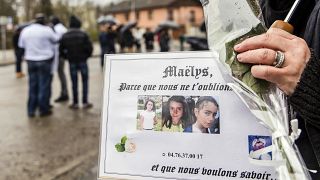 People hold pictures of Maelys de Araujo during a "white march" tribute in December 2017.