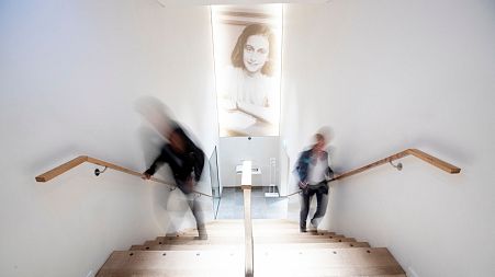 People walk up the stairs at the renovated Anne Frank House Museum in Amsterdam, Netherlands