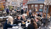 Des jeunes filles déjeunent en terrasse au Danemark. Toutes les jauges imposées aux bars et au restaurants du royaume viennent d'être levées (archive)
