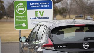 A Nissan Leaf charges at a recharge station outside the Denver Museum of Nature and Science Friday, Dec. 24, 2021, in Denver. (AP Photo/David Zalubowski)