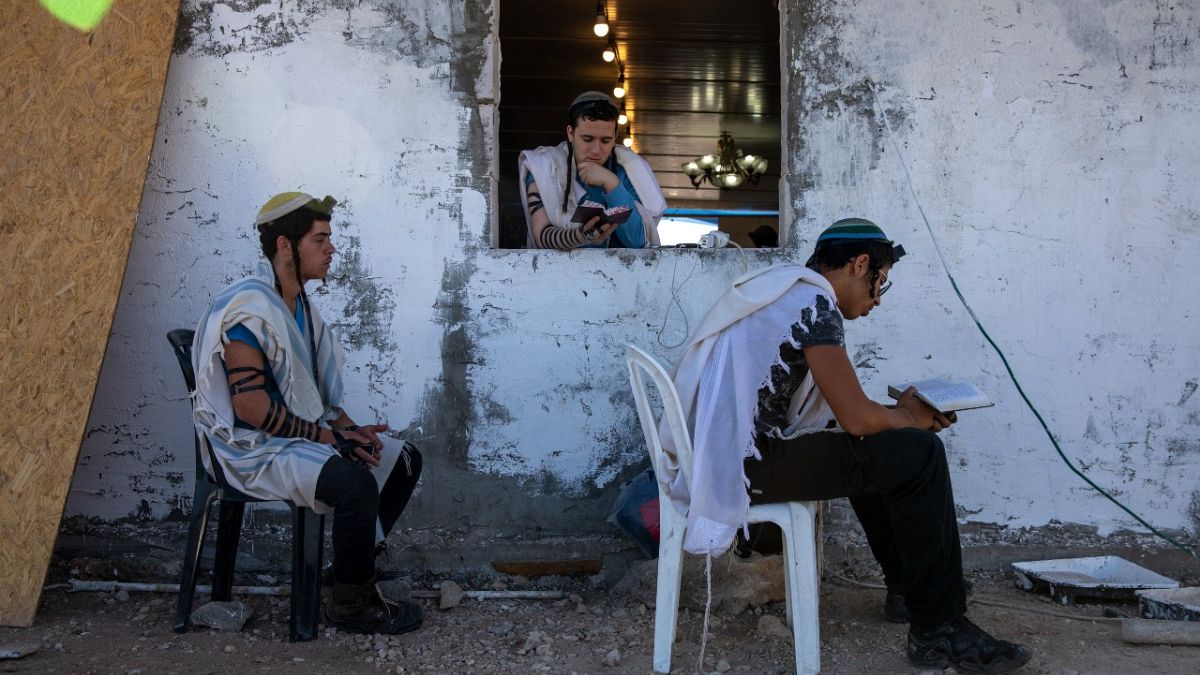 مستوطنون إسرائيليون يصلون في كنيس يهودي في بؤرة إيفياتار اليهودية العشوائية بالقرب من مدينة نابلس شمال الضفة الغربية. 28 يونيو 2021
