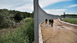 ضباط الشرطة يقومون بدوريات على طول السياج الفولاذي على طول نهر إفروس على الحدود النهرية اليونانية مع تركيا.