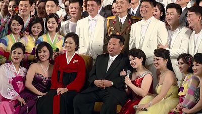 Kim and Ri posing for photos with performers