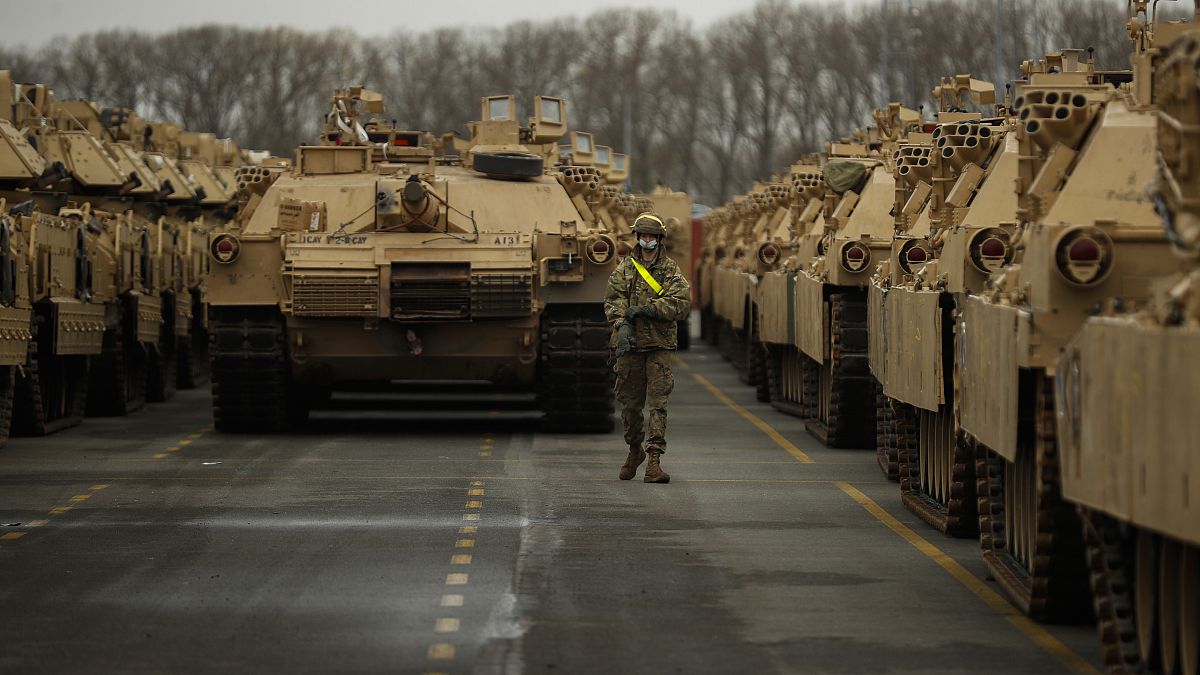 جندي أميركي بين دبابات يتم تجهيزها لتنقل إلى أوروبا (أرشيف) 