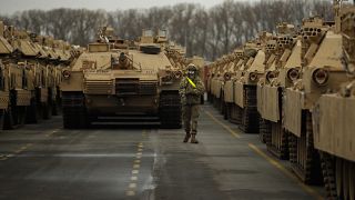جندي أميركي بين دبابات يتم تجهيزها لتنقل إلى أوروبا (أرشيف) 