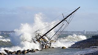 Waves crash against a sailboat in Elsinore, Denmark, Sunday Jan. 30, 2022, after a large winter storm caused havoc in Scandinavia