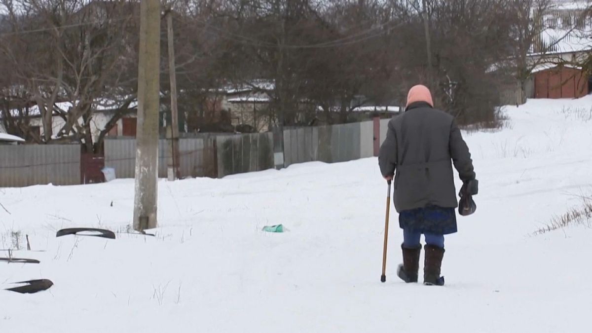 Une femme âgée du village ukrainien de Strileca marche dans la neige, près de la frontière russe 