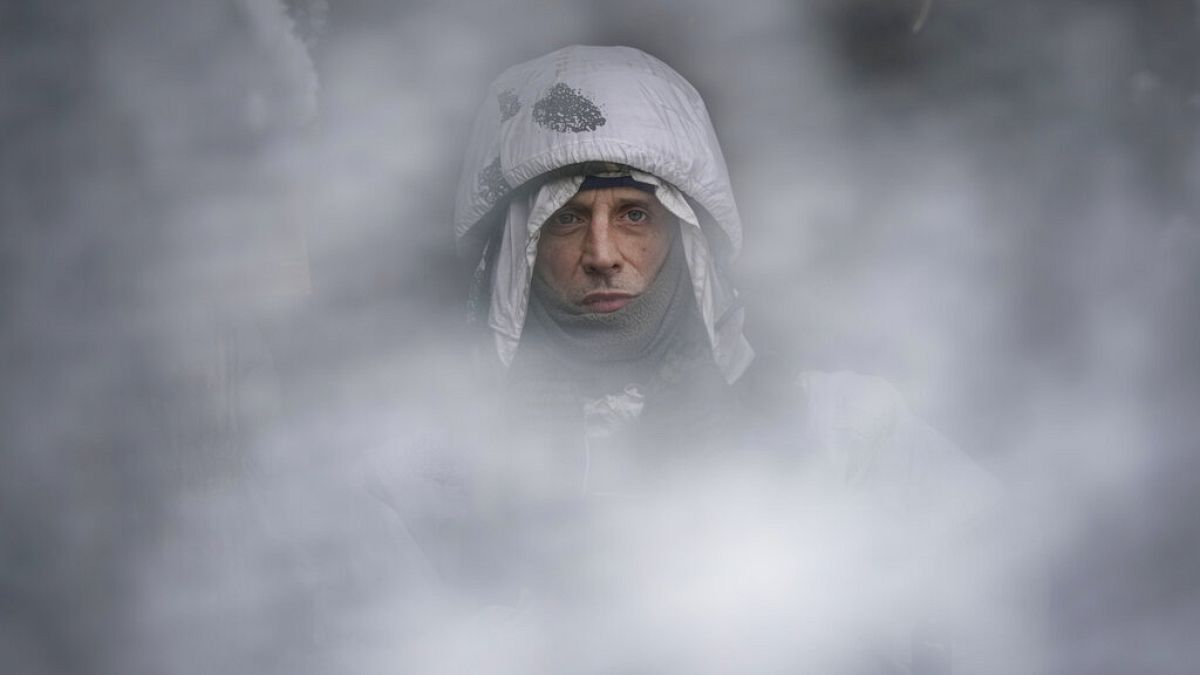 Un soldat ukrainien photographié à travers une maille de camouflage sur la ligne de front dans la région de Louhansk, dans l'est de l'Ukraine, samedi 29 janvier 2022. 