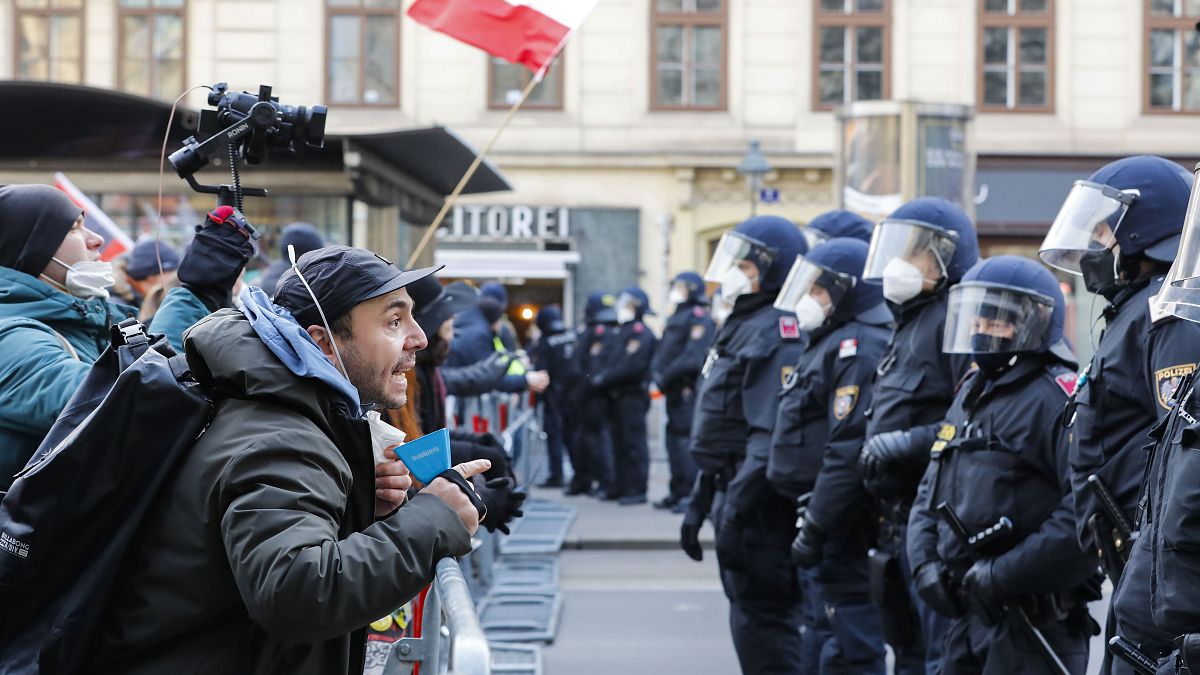 People scream at the police officers as they stop the demonstration march against the country's coronavirus restrictions around the "Vienna Ring" in Vienna, Austria