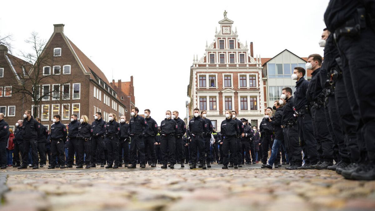 Polizeibeamte während einer Schweigeminute auf dem Marktplatz im rheinland-pfälzischen Lüneburg, 4. Februar 2022.