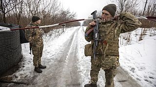 Ukrainian servicemen guard a checkpoint at the line of separation in the Luhansk region, in Luhansk, Ukraine, Thursday, Feb. 3, 2022. 