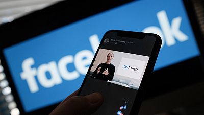 File-  This file photo taken on October 28, 2021 shows an illustration photo taken in Los Angeles of a person watches on a smartphone Facebook CEO Mark Zuckerberg unveiling th