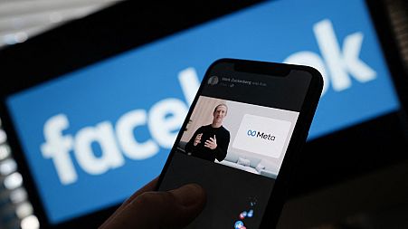 File-  This file photo taken on October 28, 2021 shows an illustration photo taken in Los Angeles of a person watches on a smartphone Facebook CEO Mark Zuckerberg unveiling th
