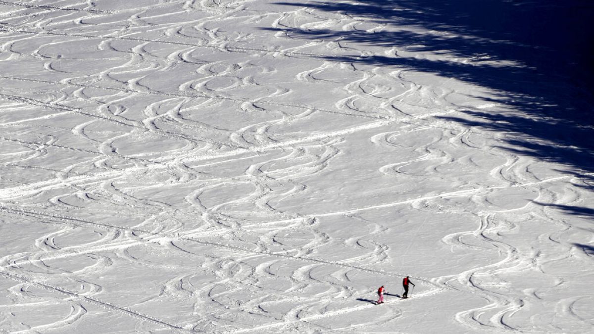 Síelők haladnak a havas tájon Filzmoos közelében, Ausztriában, 2022 január