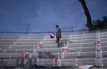 A campaign worker places French flags on seats, prior to a National Rally event in Frejus