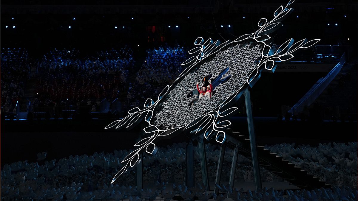 China's athletes Dinigeer Yilamujian and Zhao Jiawen prepare to light the cauldron during the opening ceremony of the 2022 Winter Olympics