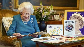 La reine examinant, au château de Windsor, des objets et messages qui lui ont été adressés pour ses précédents jubilés. Photo non datée mais récente publiée le 4 février 2022.