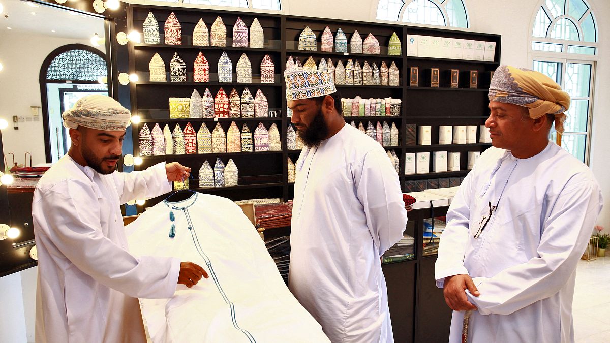 خياط عماني يعرض دشداشة في متجر بالعاصمة العمانية مسقط في 10 يناير 2022.