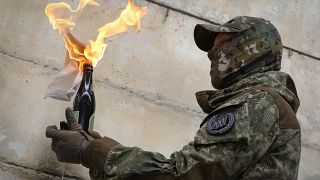 A local resident prepares a Molotov cocktail during an all-Ukrainian training campaign "Don't panic! Get ready!" close to Kyiv, Ukraine, Sunday, Feb. 6, 2022
