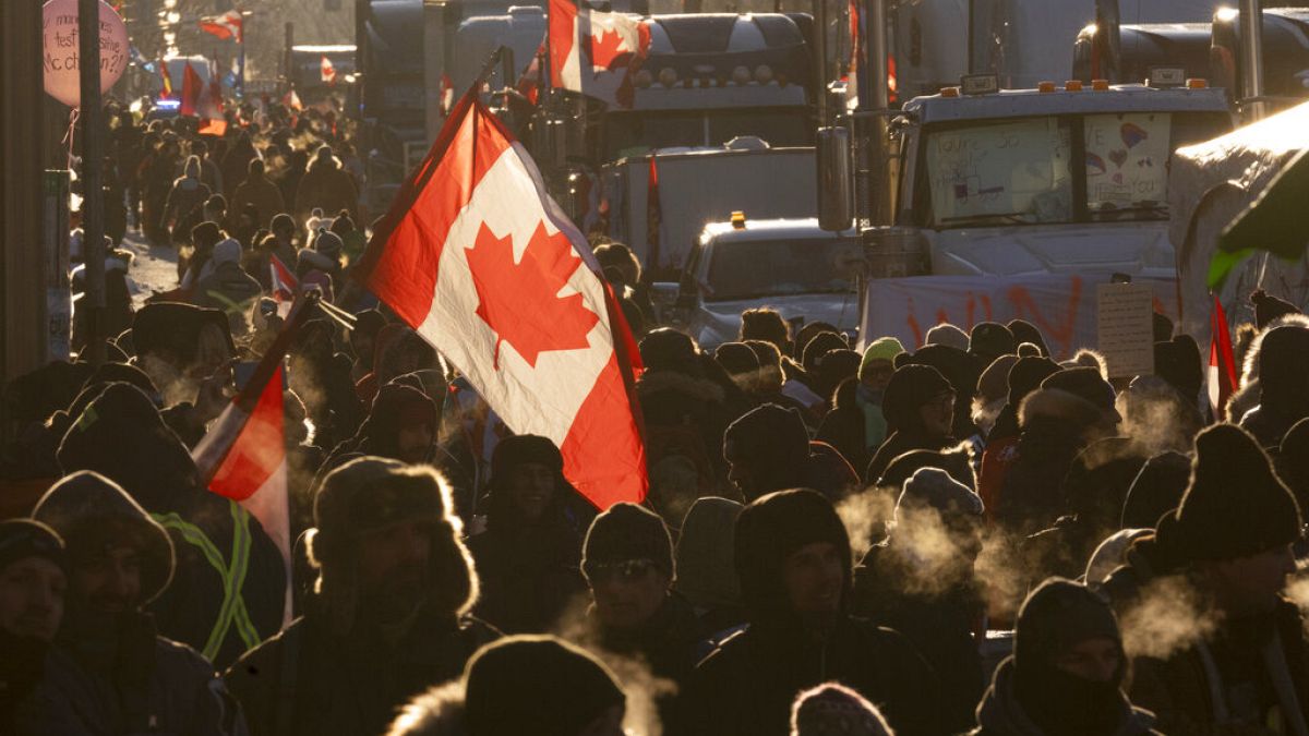 Los manifestantes caminan alrededor de los camiones estacionados en el centro de la ciudad en protesta por las restricciones del COVID-19, 5/2/2022, Ottawa, Ontario