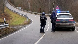 Police officers block the access road to the scene of the shooting near Kusel.