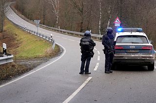 Police officers block the access road to the scene of the shooting near Kusel.