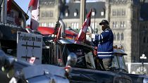 Demonstrant in Ottawa befestigt eine mit Gitterstäben geschmückte Fahne auf seinem Lkw - Aufschrift: "Trudeaus neues Zuhause".